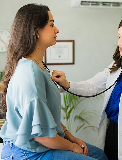 a patient having her heart checked by a doctor