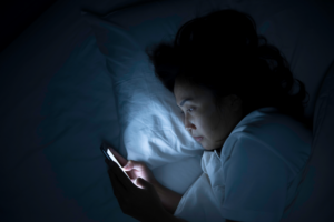 a person using their cell phone while in bed 